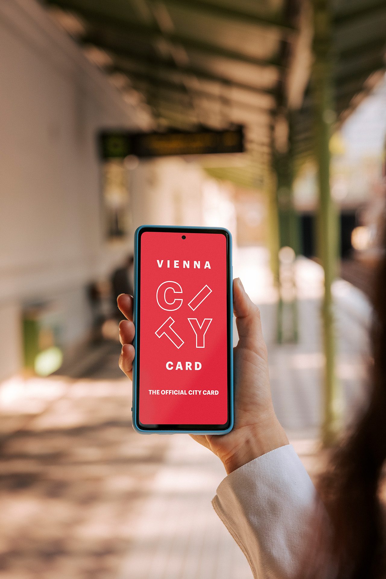 Ein Handy in der Hand, darauf der Startbildschirm von Vienna City Card zu sehen